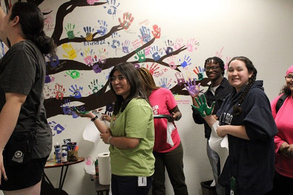 Hispanic affairs hand painting a tree